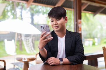 Young cute gay man makeup artist businessman in coffee shop restaurant wearing business clothes