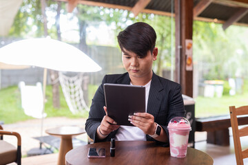 Young cute gay man makeup artist businessman in coffee shop restaurant wearing business clothes and...