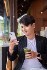 Young cute gay man makeup artist businessman in coffee shop restaurant wearing business clothes