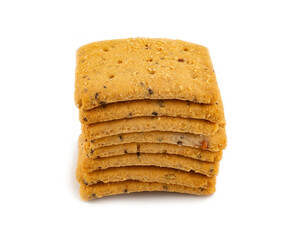 Pile of square whole grain crackers with seeds on white background – healthy baked snack food...