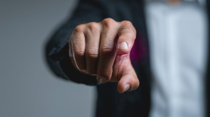Fototapeta premium Pointing Finger, Close-up: A close-up shot of a hand pointing directly at the viewer, suggesting focus, direction, or a call to action. The image conveys a sense of purpose and engagement.
