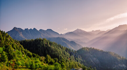 Mountain landscape with fog.  At 6,900 feet,  serene meadows, pine forests, and proximity to the Great Himalayan National Park, Sainj Valley of Kullu District, Himachal Pradesh, India.