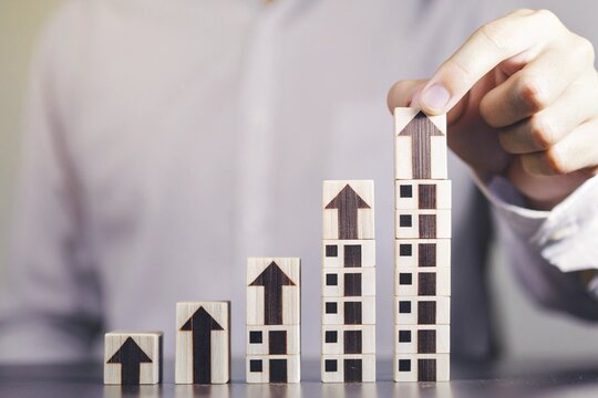 Man building growth chart with wooden blocks for business success concept