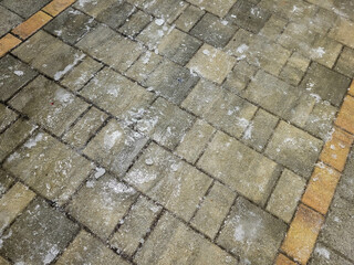 The surface of the paving slabs is covered with an ice crust. Slippery street, winter weather