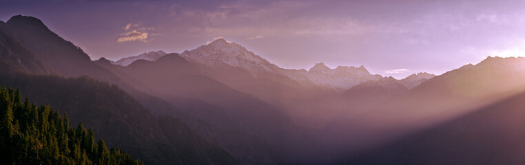 Panoramic view of sunrise in the mountains— At 6,900 feet,  serene meadows, pine forests, and proximity to the Great Himalayan National Park, Sainj Valley of Kullu District, Himachal Pradesh, India.