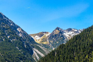 Alpine mountain landscape panorama blue sky and snow Austria.