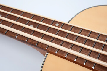 Four-string bass ukulele with wooden body and built-in tuner and pickup.