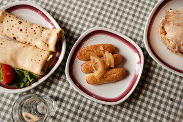 Traditional Balkan breakfast with pancakes, dessert kalac and bread sandwich with meat, cheese and vegetables. Top view.