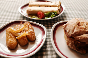 Traditional Balkan breakfast with pancakes, dessert kalach and bread sandwich with meat, cheese and vegetables. Side close up view