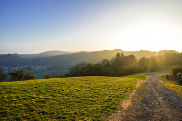 View of the landscape at the Meerfelder Maar. Nature at the crater lake in the Volcanic Eifel National Park. The surrounding area near Meerfeld at sunset in the evening.
