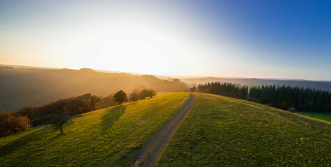 View of the landscape at the Meerfelder Maar. Nature at the crater lake in the Volcanic Eifel National Park. The surrounding area near Meerfeld at sunset in the evening.

