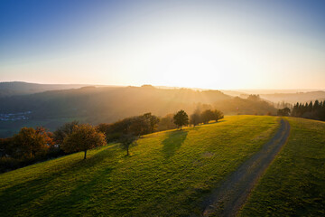 View of the landscape at the Meerfelder Maar. Nature at the crater lake in the Volcanic Eifel National Park. The surrounding area near Meerfeld at sunset in the evening.  © Elly Miller