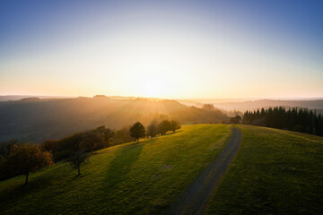 Naklejka premium View of the landscape at the Meerfelder Maar. Nature at the crater lake in the Volcanic Eifel National Park. The surrounding area near Meerfeld at sunset in the evening. 