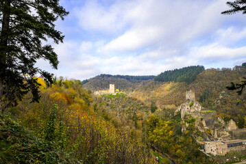 View of the autumn landscape and the Manderscheid Castles near the Eifel town of Manderscheid. Two castle ruins in the forest.
