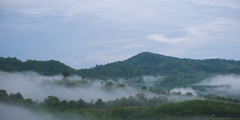 Landscape image of greenery mountains and forest on foggy morning