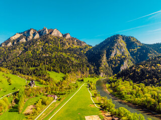 Peak Tri Koruny or Trzy Korony during day with green meadow and trees in spring. Pieniny National park in Slovakia and Poland .