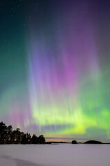 Northern lights dancing over lake in Farnebofjarden national park in north of Sweden