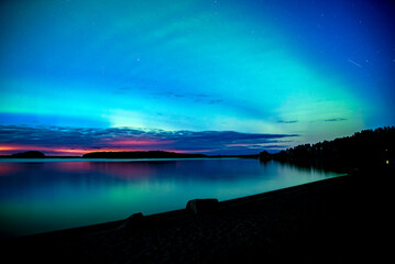 Northern lights dancing over lake in Farnebofjarden national park in north of Sweden