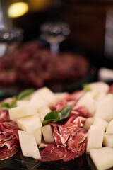 Prosciutto and melon appetizer with basil leaves