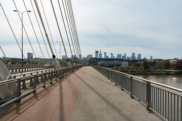 Fototapeta premium A view of the Warsaw skyline from the pedestrian and bicycle path on the Swietokrzyski Bridge. This modern bridge with a dedicated bike lane crosses the Vistula River.