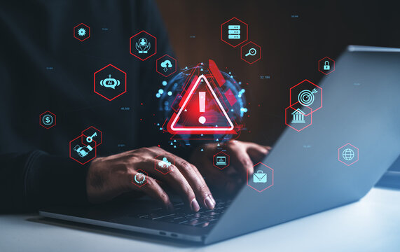 Cybersecurity alert with hacker typing on laptop surrounded by digital warning icons.