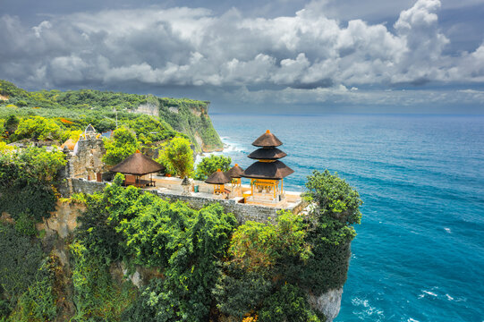 Bali's Most Iconic Landmark and popular tourist attraction Uluwatu Temple one of six key Bali temple perched on top mountain cliff on background amazing nature Bali, Indonesia Aerial view - Powered by Adobe