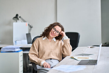 Smiling female company office worker, satisfied pretty businesswoman corporate employee sitting in...