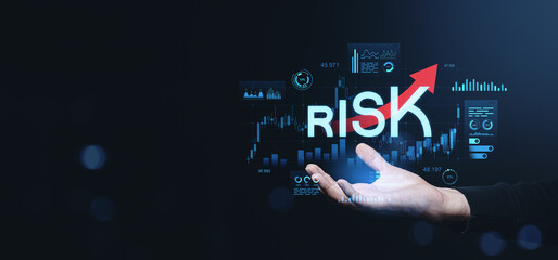 Hand holding rising risk text with forex trading chart on dark background.