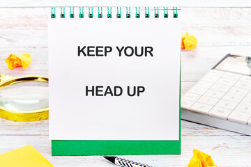 Concept words KEEP YOUR HEAD UP written on a desktop notebook with decorative elements such as a...