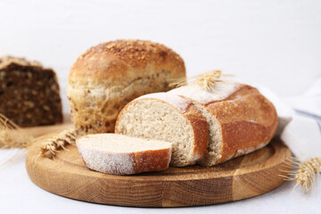 Freshly baked loaves of bread and spikes on light table, closeup