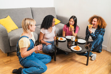 Four diverse friends sharing pizza and drinks, enjoying their time together in a cozy living room