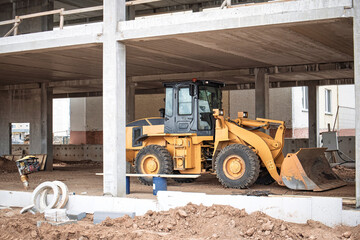 Construction machinery working on a site during the day in an urban area