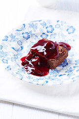 Chocolate brownie with cherry syrup . Selective focus. Copy space.	