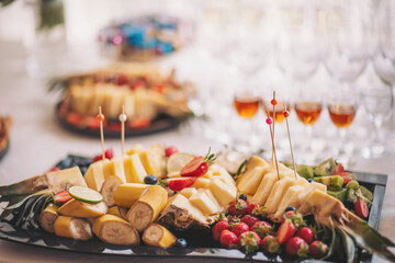 Delightful array of fresh fruits and cheeses presented elegantly at a festive gathering in a sunlit venue, inviting guests to savor each delectable bite
