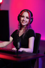 Young gamer streaming in a vibrant room with colorful lighting