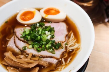 close up of Japanese ramen noodles with boiled Ajitsuke Tamago, spring onion and soft tender slice pork with noodles in soy sauce with copy space