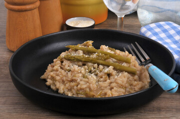 Assiette de risotto aux asperges vertes fait maison avec une fourchette en gros plan