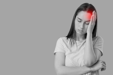 Fototapeta premium Tired young woman suffering from headache on grey background