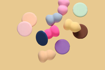 Flying different makeup sponges on yellow background