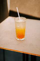 Refreshing beverage served in a clear glass on a textured table in afternoon light