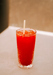 Refreshing cherry beverage served in a clear glass on a marble countertop at sunset