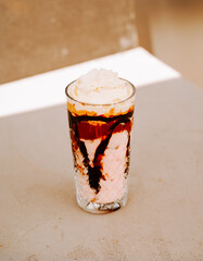 Delicious dessert drink served in a glass on a light background at a cafe