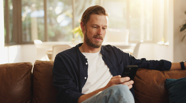 Reading, sofa and man with phone in home for social media, online networking and chat on mobile app. Relax, news and person on smartphone for internet, contact and message notification on weekend