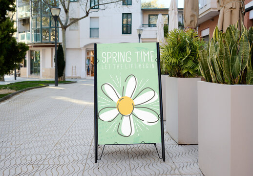 A-frame sign mockup stands empty on a city street corner.