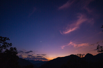 Milky Way above mountains at night in autumn. Landscape with mountain valley, low clouds, purple starry sky with milky way. The Milky Way shines on a cold night in the north of Thailand