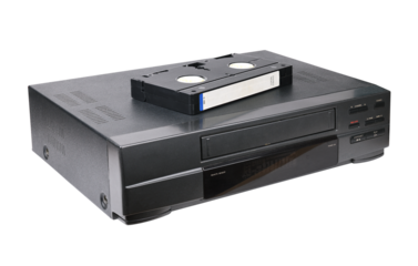 Classic VCR with cassette lying on top isolated on white background.