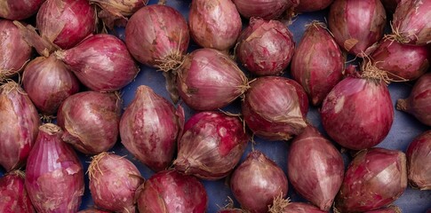 Background of onion heads at the market - natural texture and healthy food concept. Organic vegetable background for design and advertising