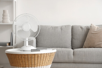 Modern electric fan on coffee table at home