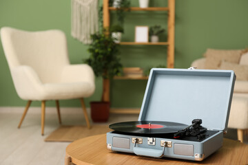 Record player with disk on coffee table in room