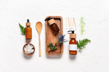 Spa composition with cosmetic products and plants on light background
